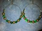 pair of large gold hoop earrings with green glass beads and gold 