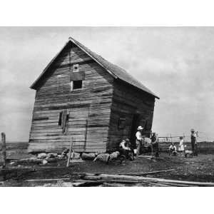 com Ramshackle Barn with Farmer and Kids in Front Sharpening a Sickle 